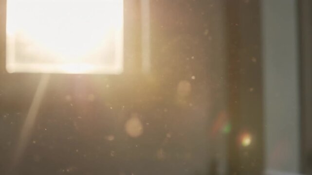 Bright light shining through a window with dust particles floating in the air creating a soft glow