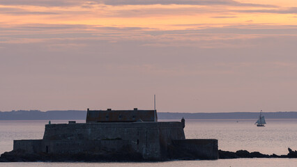 Fort National silhouette against sunset orange sky Saint Malo France scenic view