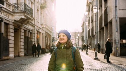 Vilnius, Lithuania. Young Beautiful Pretty Caucasian Girl Woman Dressed In Green Jacket And Blue Hat Enjoying Life And Smiling On Street Of Town.