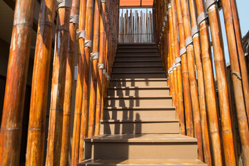 Stair with bamboo decorated wall and handrail for hold on to wood to go up and down.