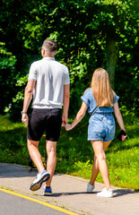 Obraz premium A man and a woman walk in a summer park 