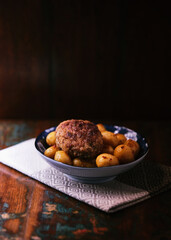 Fried meatballs with potatoes on a rustic background. Selective and soft focus.	
