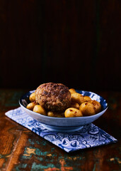 Fried meatballs with potatoes on a rustic background. Selective and soft focus.	