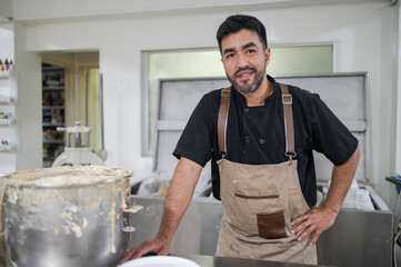 Latino man working as baker in kitchen
