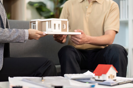 Real estate agent presenting model home to client in office