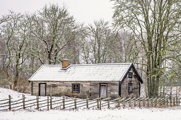 Idyllic old cottage with a wooden fence in a snowy landscape © Lars Johansson