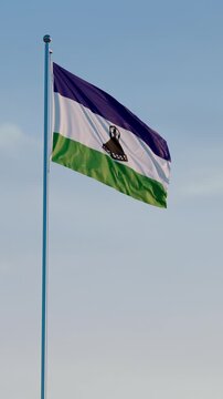 Lesotho, Maseru: Cinematic Vertical Waving National Flag Against Blue Sky