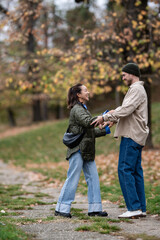 Fototapeta premium Happy diverse couple enjoying romantic autumn park stroll