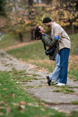 Fototapeta premium Happy couple embracing, laughing in autumn park