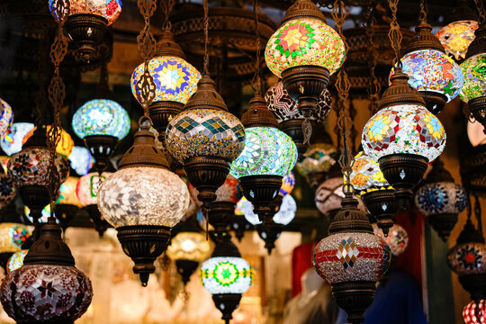 A vibrant mosaic lantern with colorful glass pieces creates a warm, decorative glow in an oriental-style setting - Powered by Adobe