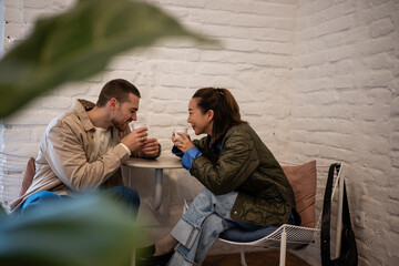 Young couple enjoying coffee date communicating and laughing