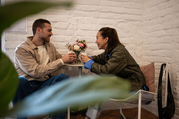 Mixed-race couple enjoying coffee date at cafe