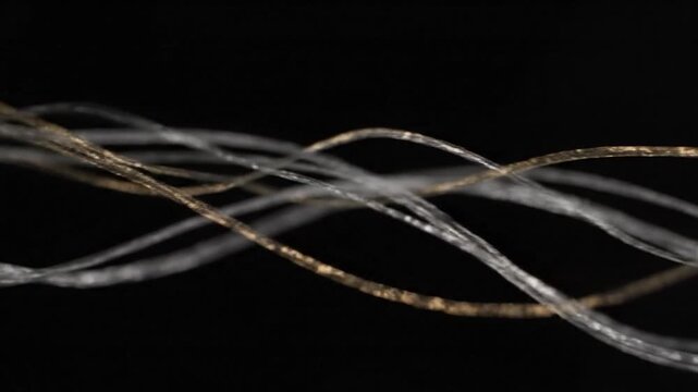 Intricate twisted silver and golden threads against a deep black backdrop