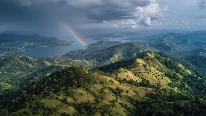 A sweeping mountain landscape with green hills, a large lake dotted with islands, and a rainbow arcing across a cloudy sky. Concept Majestic Mountains, Emerald Hills, Island-dotted Lake, Rainbow Arc