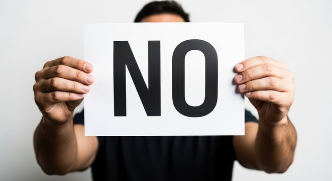 Man showing a white paper with the word NO. Protest and rejection concept using a simple sign. Disagreement and refusal message.