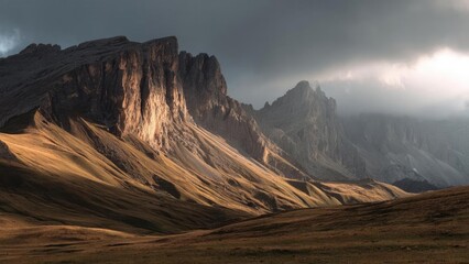 Rugged mountain range with sunlit slopes in the foreground and a dark, stormy sky looming overhead. Concept Rugged mountains, Sunlit slopes in foreground, Dark stormy sky, Dramatic landscape