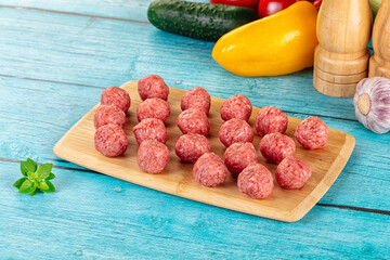 Raw beef meatballs over board