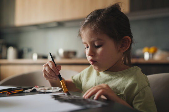 young female artist meticulously applying delicate brush techniques during creative session