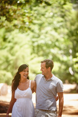 Obraz premium Hug, couple and laugh in nature for travel, marriage commitment and talking for love on holiday. Smile, man and woman embrace outdoor for romance, loyalty and care with funny story on vacation