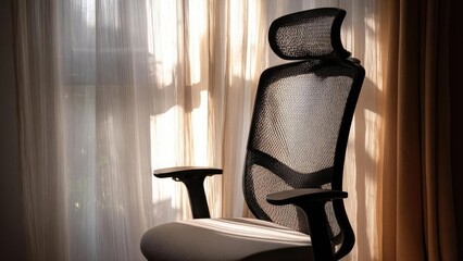 A black mesh ergonomic office chair by a sunlit window with sheer curtains. Concept Black mesh ergonomic office chair, Sunlit window, Sheer curtains, Bright airy workspace, Minimalist office setup