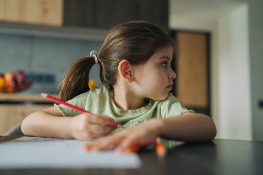 reflective girl gazes, woman with pencil decides on next artistic idea during tranquil kitchen moment - Powered by Adobe