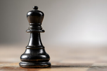 Black chess piece on a blurred gray background