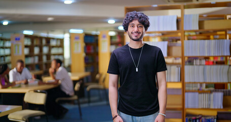 Indian Asian young adult gen z man confident student standing proud look camera indoor book store library happy smiling boy staring cam do casual pose enjoy new day time college © Raushan_films