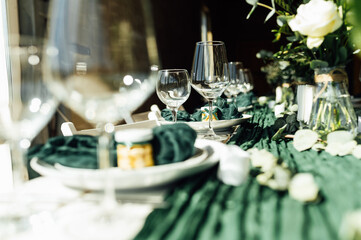Elegant festive table setting with green decor and glassware