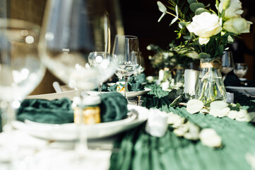 Elegant festive table setting with green decor and glassware