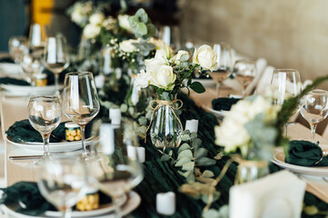 Elegant festive table setting with green decor and glassware