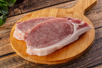 Raw pork steak over board