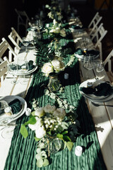 Elegant festive table setting with green decor and glassware