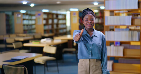 African young adult gen z happy student indoor library look camera show thumbs up hand sign ready for exam smiling girl staring cam do pose enjoy day time inside college