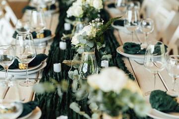 Elegant festive table setting with green decor and glassware