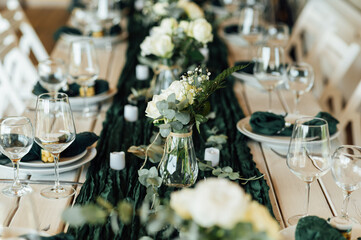 Elegant festive table setting with green decor and glassware