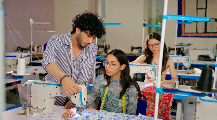 Indian Asian young adult gen z man male teach woman wear measure tape neck learn new clothe craft sewing design course indoor class room teen girl pupil boy guy help stitch skill day college place