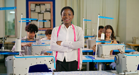 African young adult gen z lady woman wear tape around neck cross arm class room .Teen age pupil girl look cam fold hand do casual pose learn new sewing craft skill course indoor day college place