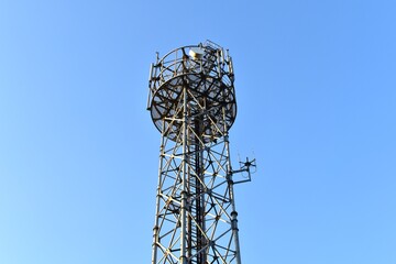 Looking up at a mobile phone tower on a sunny day.