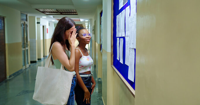 Indian young adult gen z upset sad pupil girl look notice do check exam results study report campus indoor area. Stress female pair feel bad wear bag read new paper list data notice college place