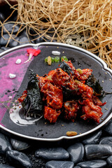 Beautifully plated chicken pieces with mulberry leaves