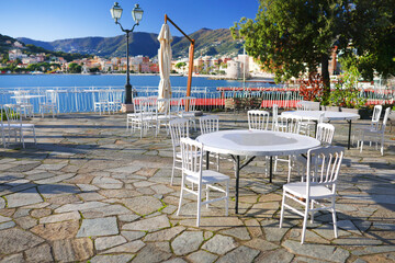 Fototapeta premium White furniture on terrace by sea on sunny day. Tourism and recreation, Europe. Nature and architecture of Italy. Design backdrop.