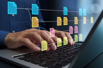 Version control for source code or documents. Revision history and change tracking. Businessperson using laptop computer to edit file.