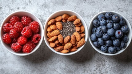 Bowl of fresh fruits and nuts arranged on a gray surface for a healthy snack option