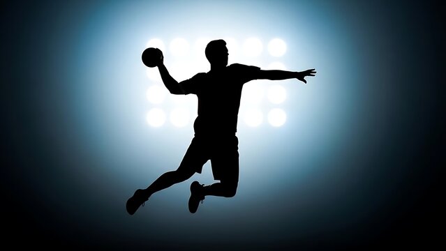Silhouette of handball player throwing ball against bright spotlight in stadium