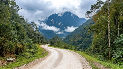 Fototapeta premium Winding dirt road through lush mountain landscape.
