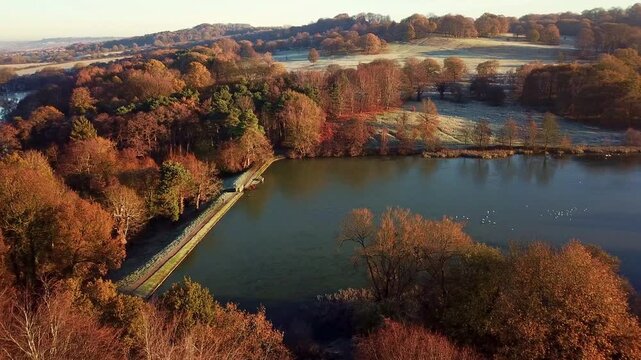 Drone View Of Frozen Pond In Peak District National Park With Ducks And Birds Sat On The Lake In Winter At Golden Hour Sunrise Sliding Left To Right
