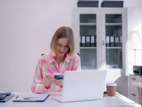 Caucasian businesswoman working at office with laptop and documents on his desk, financial adviser analyzing data.
