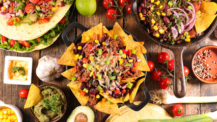 Mexican food with fajitas, chili con carne, nachos with avocado, beef and cheese, top view