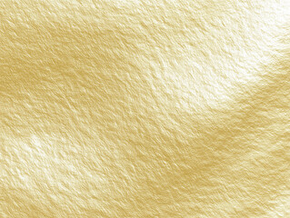 A close up view of a golden textured surface with slight variations in color and light reflection.