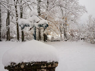 Cross monument covered in snow symbolizing faith, memorial, and peace
